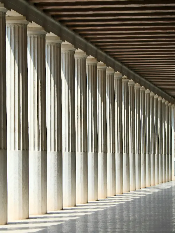 Perspective view of a long row of classical stone columns indoors