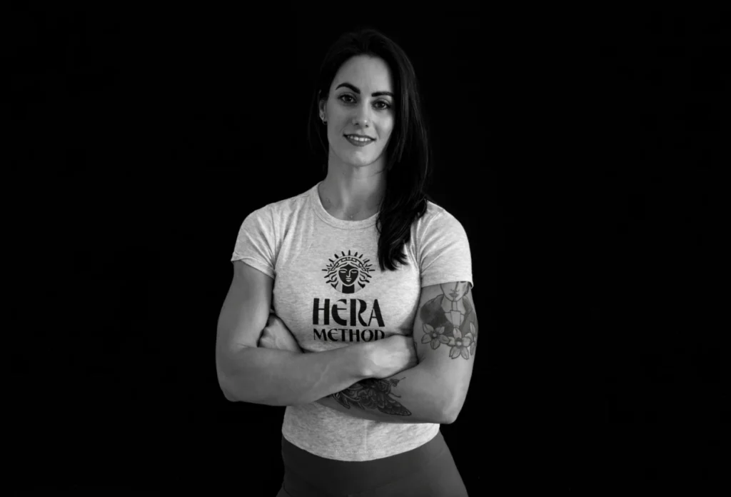 Woman with crossed arms wearing a Hera Method t-shirt