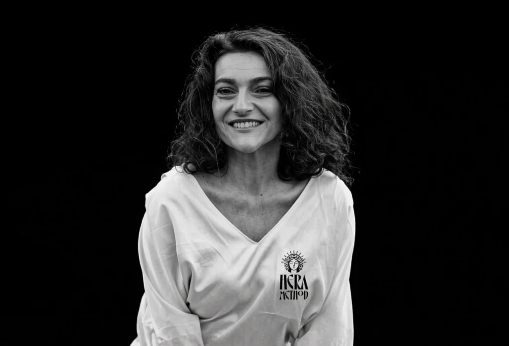 Woman smiles, wearing a shirt with "IKRA METHOD" logo