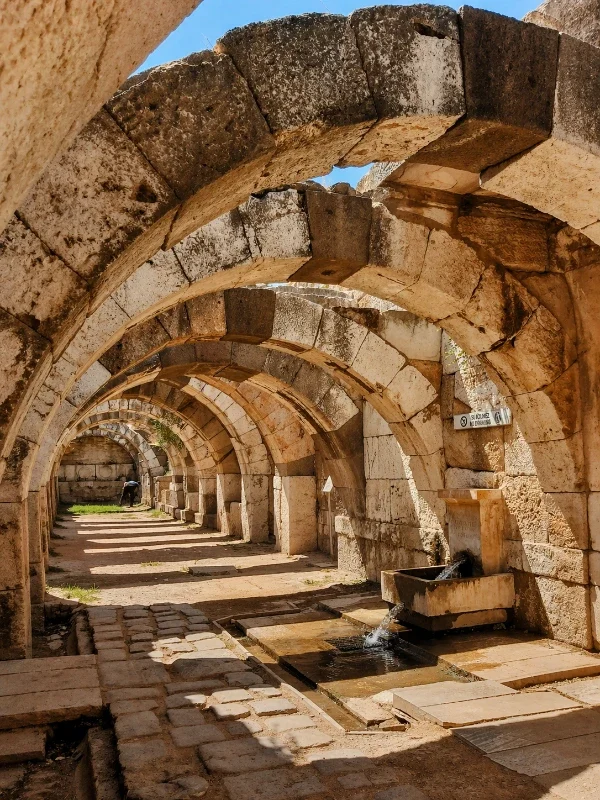 Ancient Roman aqueduct arches with flowing water, historical site